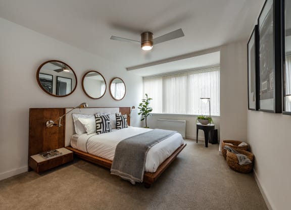 a bedroom with a bed and two mirrors on the wall