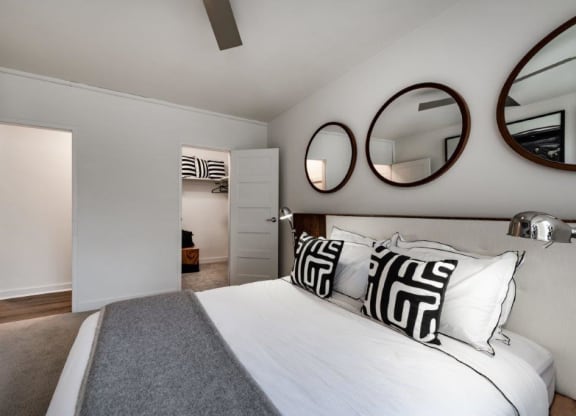 a bedroom with a bed and mirrors on the wall