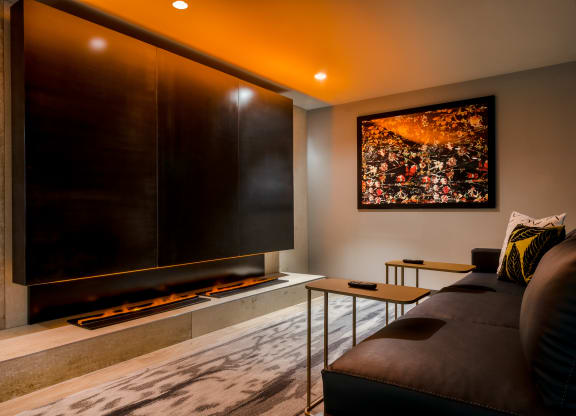 a living room with a large screen tv on the wall and a couch in front of it