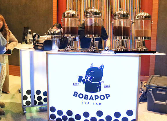 A Bobapop Team Bar with a woman standing beside it.