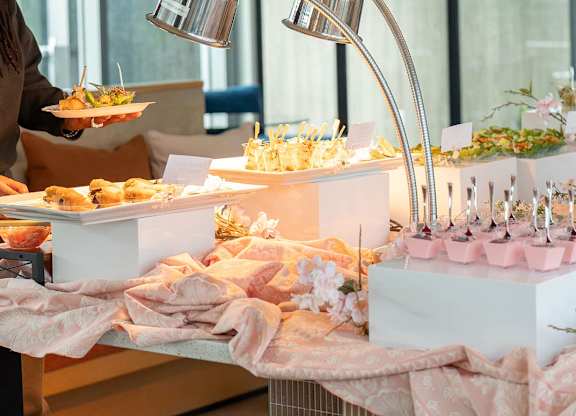 A table with desserts and a person holding a plate at Rooftop and Rose at 901W