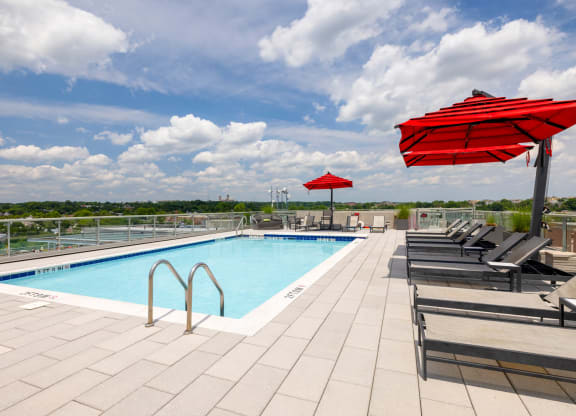 a swimming pool with chaise lounge chairs and umbrellas