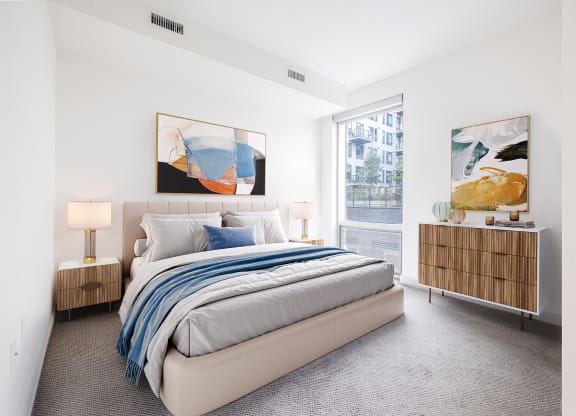 a bedroom with a large bed and two large paintings on the wall