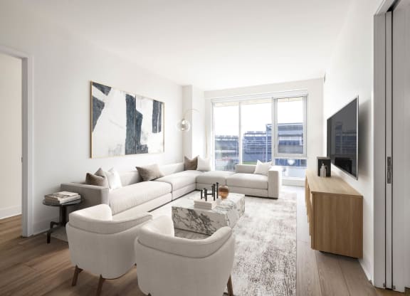 a living room with white furniture and a large window