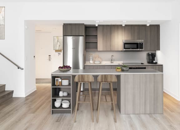 a kitchen with a large island with two stools in front of it