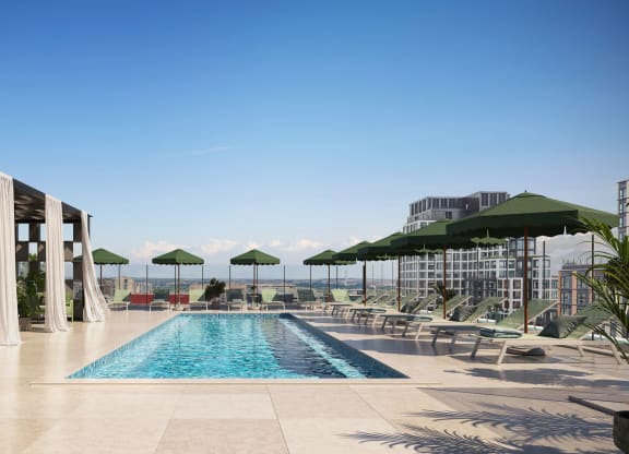 a swimming pool on the rooftop of a hotel with chairs and umbrellas