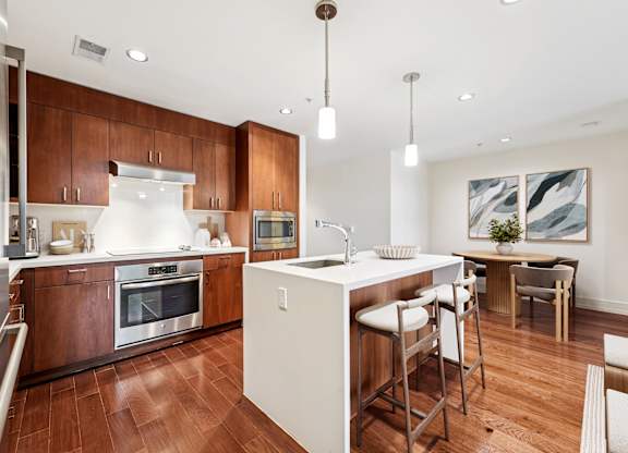 A modern kitchen with wooden cabinets and a white island.