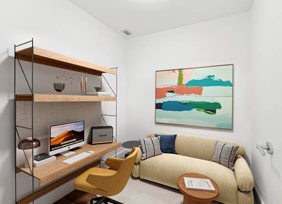 A room with a yellow chair and a couch with a painting on the wall.