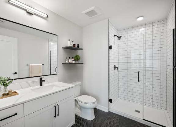 a white bathroom with a shower and a sink and a toilet