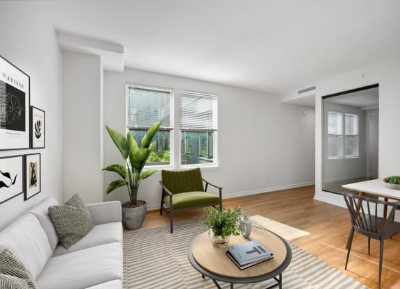 a living room with a couch and a coffee table and a dining room