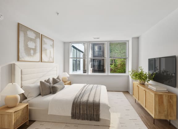 a white bedroom with a large bed and a window