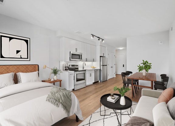 a bedroom with a bed and a couch and a kitchen