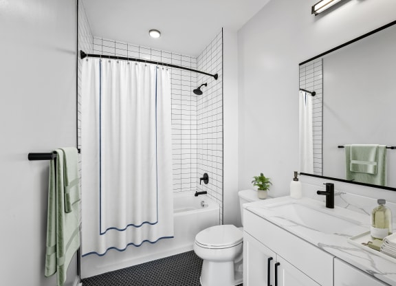 a white bathroom with a shower and a toilet and a sink