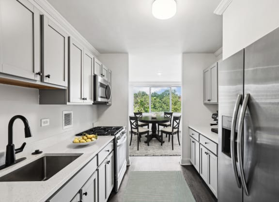 a kitchen with white cabinets and stainless steel appliances and a stainless steel refrigerator