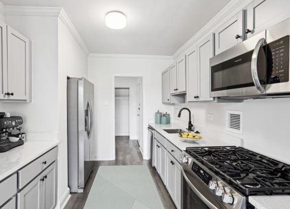 a white kitchen with stainless steel appliances and white cabinets