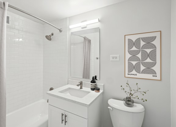 a bathroom with a toilet sink and shower and a mirror
