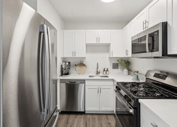 a kitchen with stainless steel appliances and white cabinets