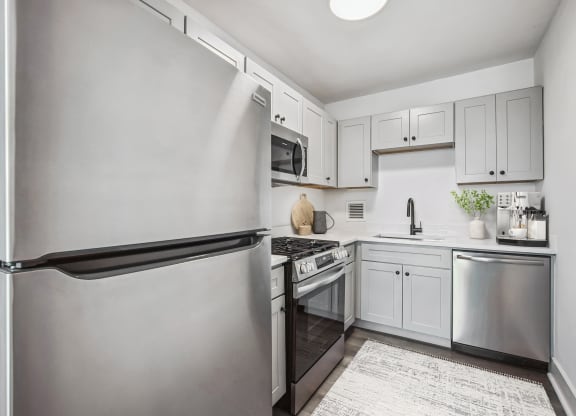 a white kitchen with stainless steel appliances and white cabinets