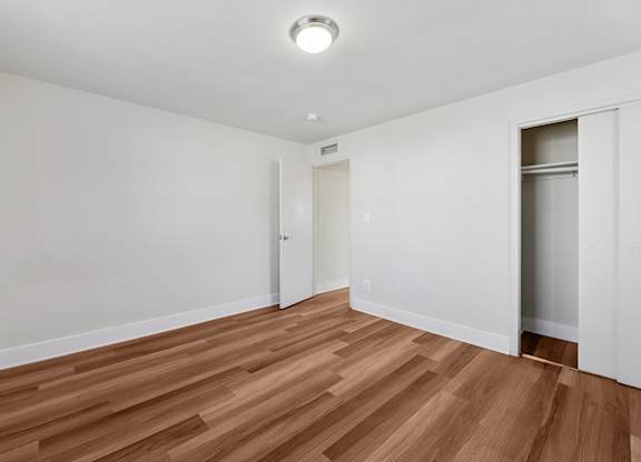 A room with wooden flooring and white walls.