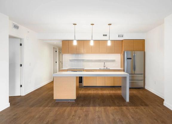 A kitchen with wooden cabinets and a white island.