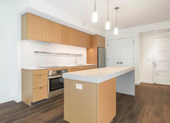 A modern kitchen with wooden cabinets and a white countertop.