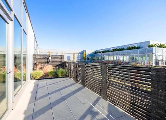 A modern building with a glass facade and a wooden fence.