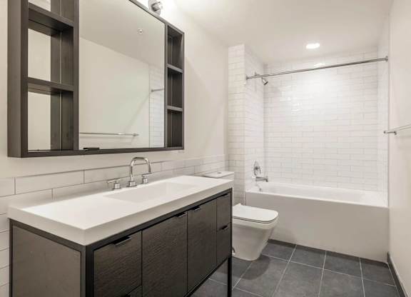 A modern bathroom with a white sink and a white toilet.