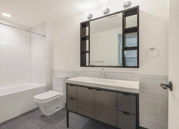 A white toilet sits next to a sink in a modern bathroom.