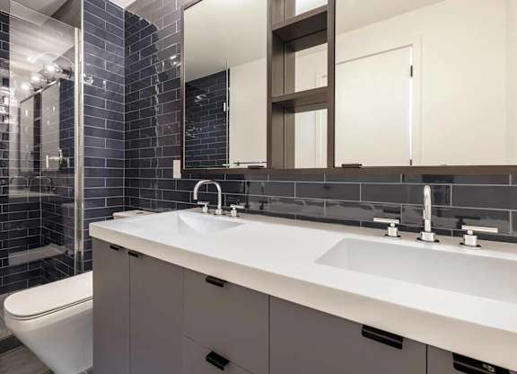 A bathroom with a white sink and a white toilet.