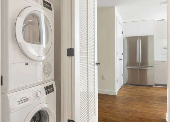 A white washing machine and dryer stacked on top of each other.