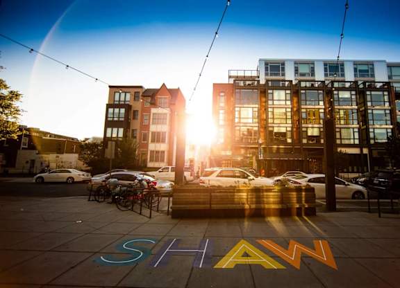 A sunny day in a city with a street named SHAW.