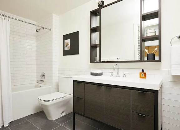A white bathroom with a toilet, sink, and mirror.