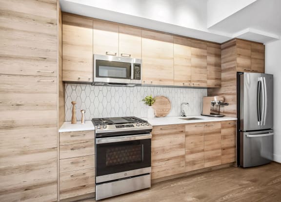 a kitchen with stainless steel appliances and wooden cabinets at The Grace and Reva, Arlington, Virginia