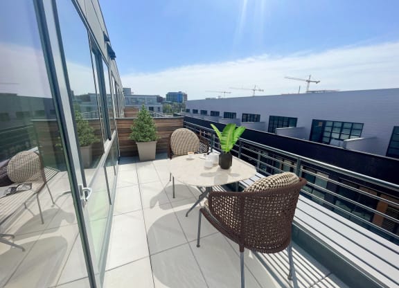a terrace with a table and chairs on a balcony