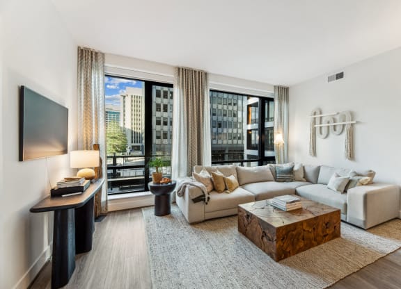 a living room with a couch and a coffee table and large windows at The Grace and Reva, Virginia