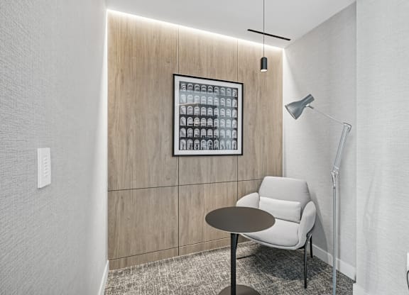 A modern room with a table, chair and a lightbox on the wall.