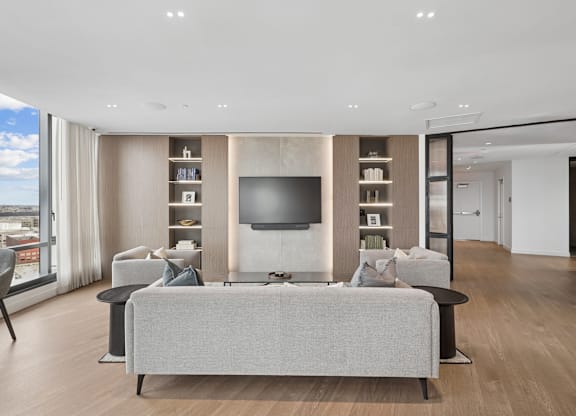 A modern living room with a grey sofa and a television.