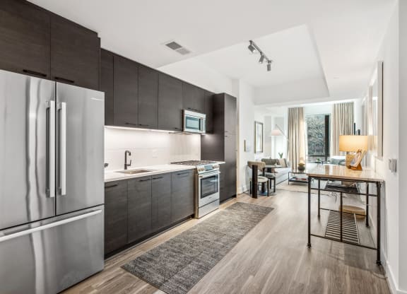 a kitchen with stainless steel appliances and wooden floors at The Grace and Reva, Virginia, 22202