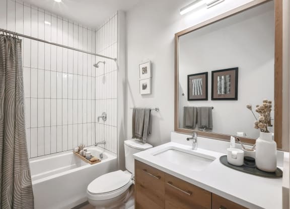 a bathroom with a shower toilet and sink and a mirror at The Grace and Reva, Arlington, VA, 22202