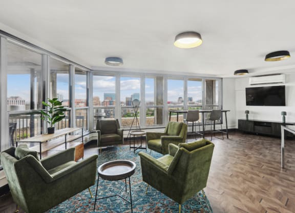 a living room with couches and chairs and a balcony with a view