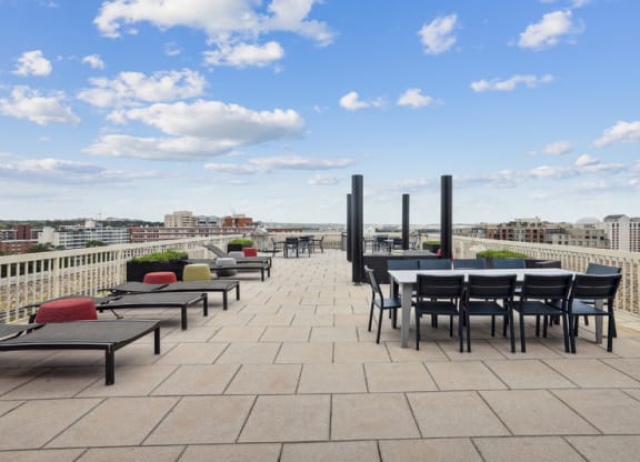 a terrace with tables and chairs on top of a roof