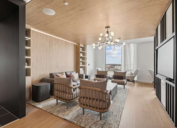 A modern living room with a wooden ceiling and furniture.