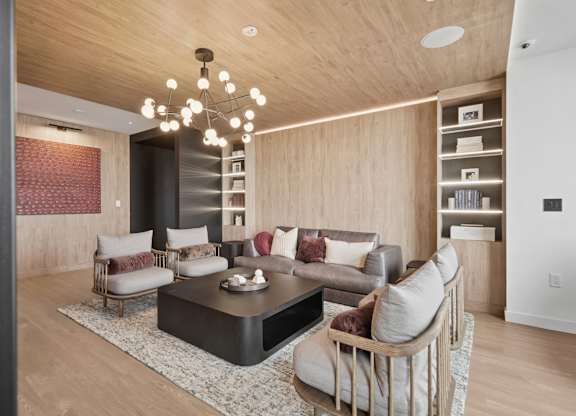 A modern living room with a wooden ceiling and a black coffee table.