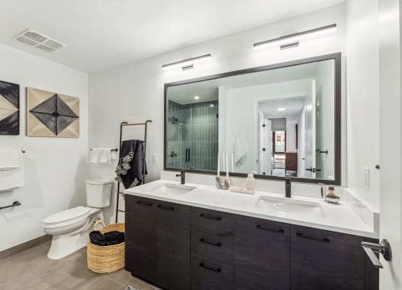 a bathroom with a large mirror and a sink and a toilet at The Grace and Reva, Arlington, VA, 22202