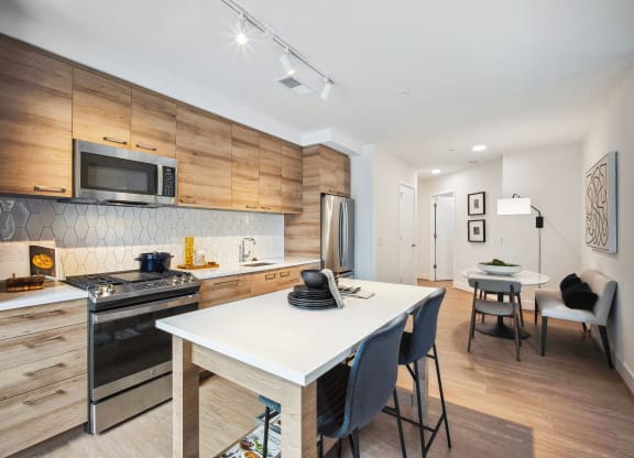 a kitchen and dining area with a table and chairs and a stove and microwave at The Grace and Reva, Arlington, 22202