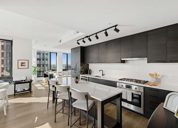 A modern kitchen with a dining table and chairs.