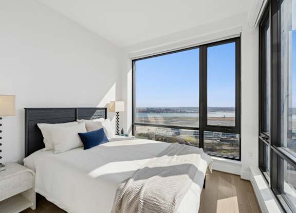 A bedroom with a large bed and a view of the city.