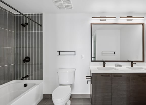A white toilet sits next to a white sink in a bathroom.