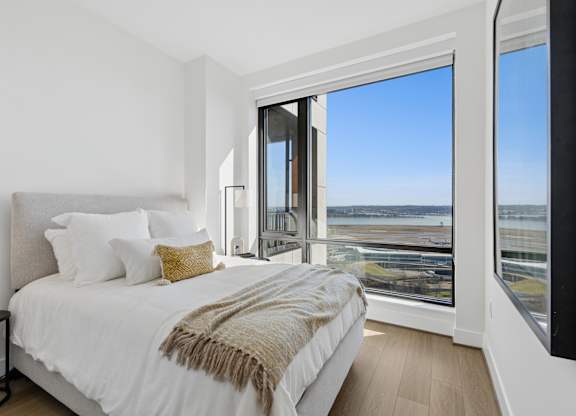 A bedroom with a large bed and a view of the ocean.