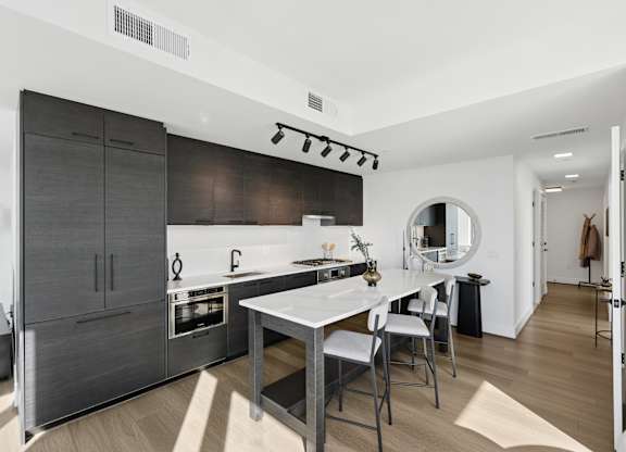 A modern kitchen with a large island and a dining table.